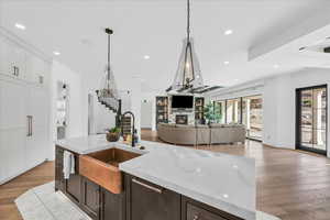 Kitchen featuring pendant lighting, light hardwood / wood-style floors, light stone countertops, and sink