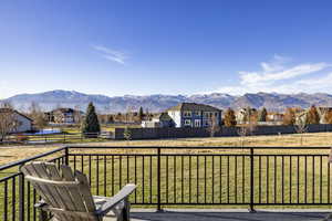 Wooden deck featuring a lawn and a mountain view