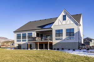 Back of property with central AC, a mountain view, and a yard