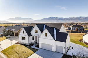 View of front facade featuring a mountain view, a front yard, and a garage