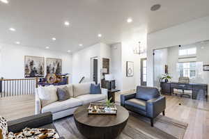 Living room with a notable chandelier and light hardwood / wood-style floors