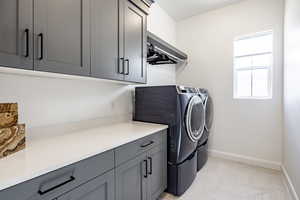 Laundry area featuring cabinets, independent washer and dryer, and light parquet flooring