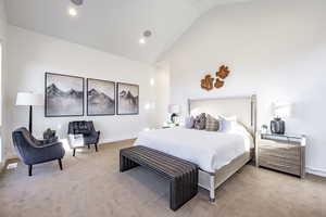 Bedroom featuring lofted ceiling and light carpet