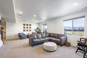 Living room featuring a mountain view, light colored carpet, and a textured ceiling