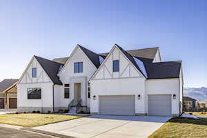 Tudor-style house featuring a front yard and a garage