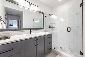 Bathroom with a shower with door, vanity, and tile patterned flooring