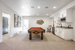 Rec room featuring light carpet, sink, a textured ceiling, and billiards