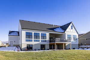 Rear view of house with a lawn and a wooden deck