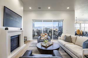 Living room featuring a mountain view, light wood-type flooring, a wealth of natural light, and an inviting chandelier