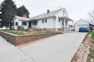 View of front of home featuring an outbuilding, a garage, and a front lawn