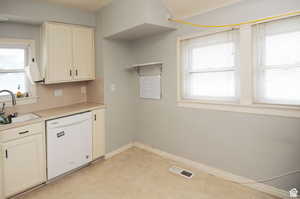 Kitchen with a wealth of natural light, sink, and white dishwasher