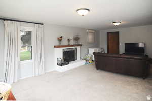 Living room with a fireplace and carpet flooring