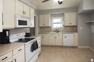 Kitchen with ceiling fan, sink, and white appliances