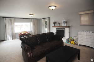 Carpeted living room featuring a fireplace and a textured ceiling