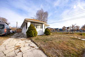 View of side of property with an outdoor structure and a garage