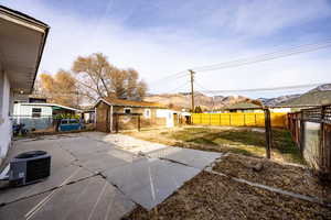 View of patio with central air condition unit, a mountain view, and an outbuilding