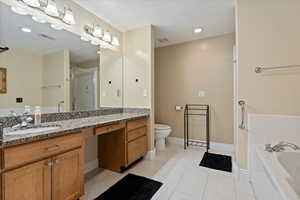 Huge ensuite bathroom within the owner’s suite, featuring Granite Countertops, a jacuzzi tub, and a walk-in shower