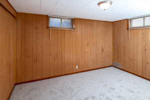 Bedroom featuring wood walls and light carpet