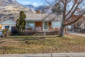 Ranch-style house featuring a mountain view and a front yard