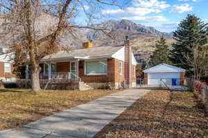 View of front of home featuring a mountain view, a garage, a front yard, and covered porch