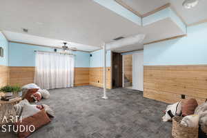 Interior space with carpet, wood walls, and ornamental molding