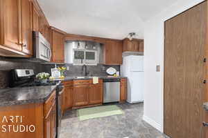 Kitchen featuring decorative backsplash, sink, and appliances with stainless steel finishes