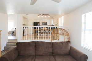 Living room with a wealth of natural light, hardwood / wood-style floors, and ceiling fan