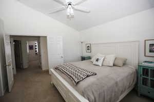 Carpeted bedroom with high vaulted ceiling and ceiling fan