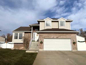 Tri-level home featuring a front yard and a garage