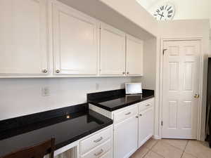 Kitchen featuring white cabinets and light tile patterned flooring