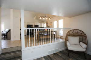 Sitting room with hardwood / wood-style flooring and lofted ceiling