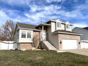 Split level home featuring a garage and a front yard