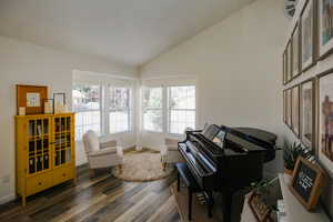 Sitting room with dark hardwood / wood-style flooring and lofted ceiling