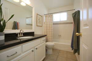 Full bathroom featuring tile patterned flooring, vanity, shower / bath combo, and toilet