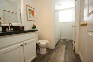 Bathroom featuring vanity, wood-type flooring, and toilet