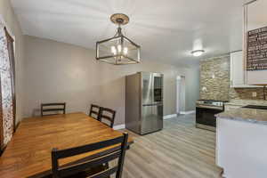 Dining space featuring LVP / wood-style floors, chandelier, updated fridge is negotiable