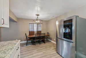 Dining space featuring LVP / wood-style floors, chandelier, updated fridge is negotiable