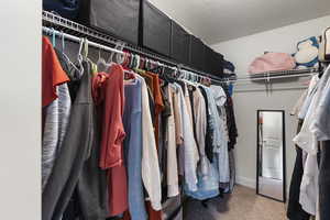 Spacious Master walk-in closet featuring carpet