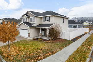 View of front facade with a mountain view, a front lawn, and a garage