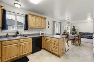 Kitchen featuring dishwasher, kitchen peninsula, sink, and an inviting chandelier