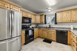 Kitchen featuring black appliances, sink, and a textured ceiling