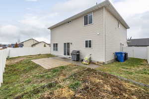 Rear view of property featuring a lawn and a patio area