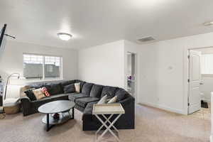 Living room with a textured ceiling and light carpet