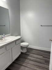 Bathroom with vanity, wood-type flooring, and toilet