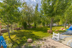View of green lawn featuring view of scattered trees