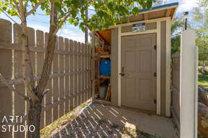 View of outbuilding featuring fence and an outbuilding