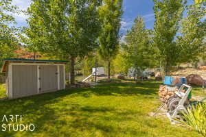 View of grassy yard with a shed and an outdoor structure
