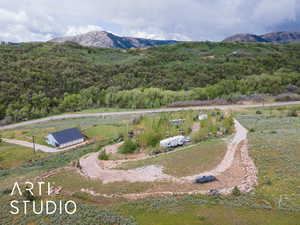 View from above of property featuring a heavily wooded area and a mountain backdrop