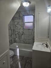 Full bathroom featuring vanity, toilet, a textured ceiling, and tiled shower / bath