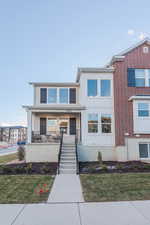 View of front of property with a porch and a front yard